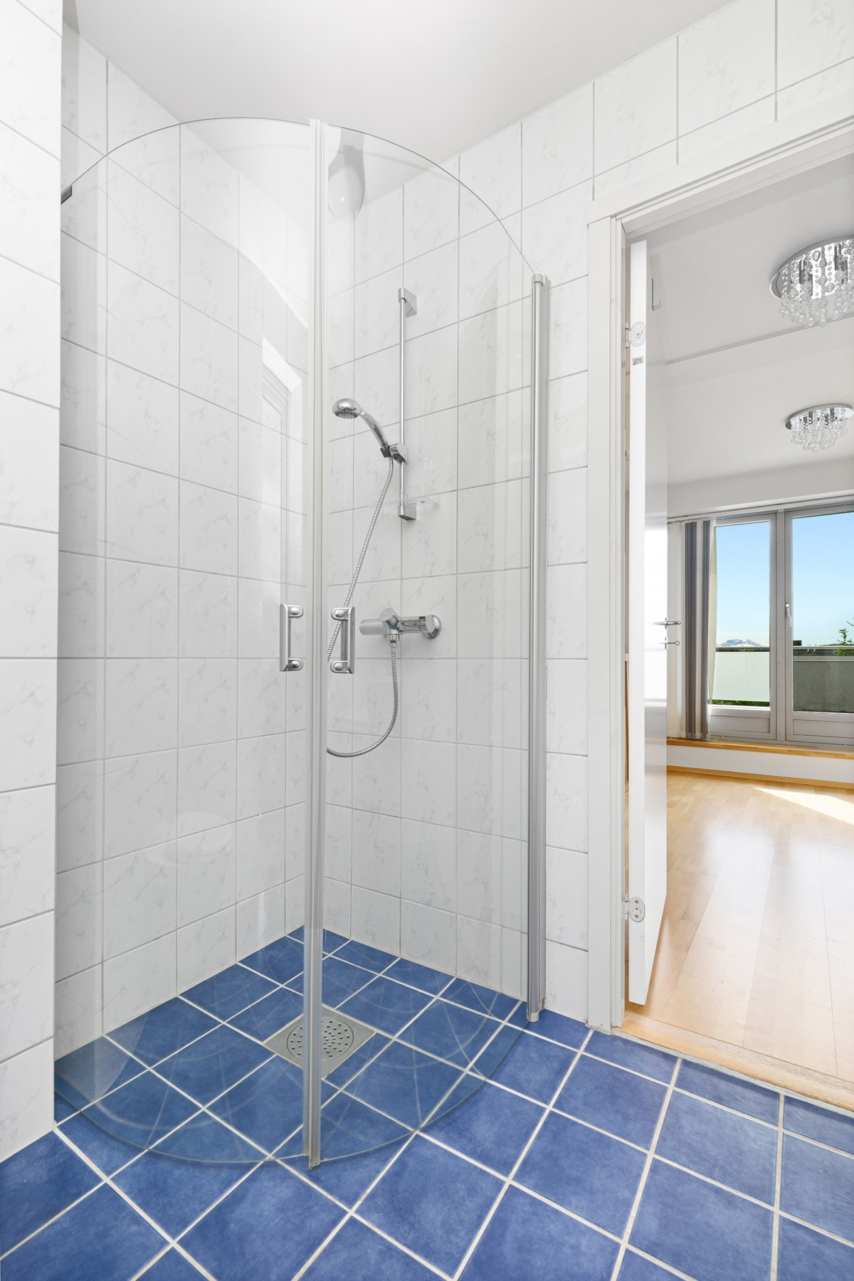 Badet er utstyrt med dusjhjørne, servant og vegghengt toalett