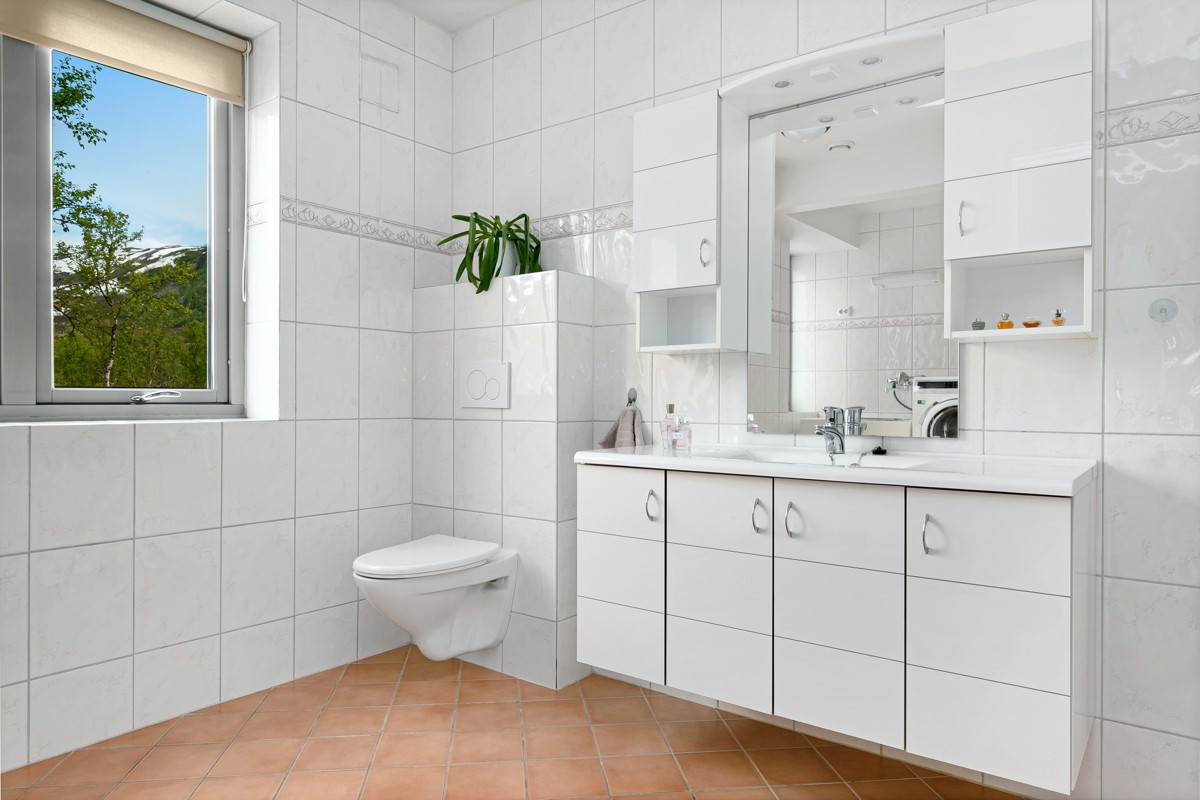 Badet i 1.etasje er komplett flislagt og har innlagt gulvvarme