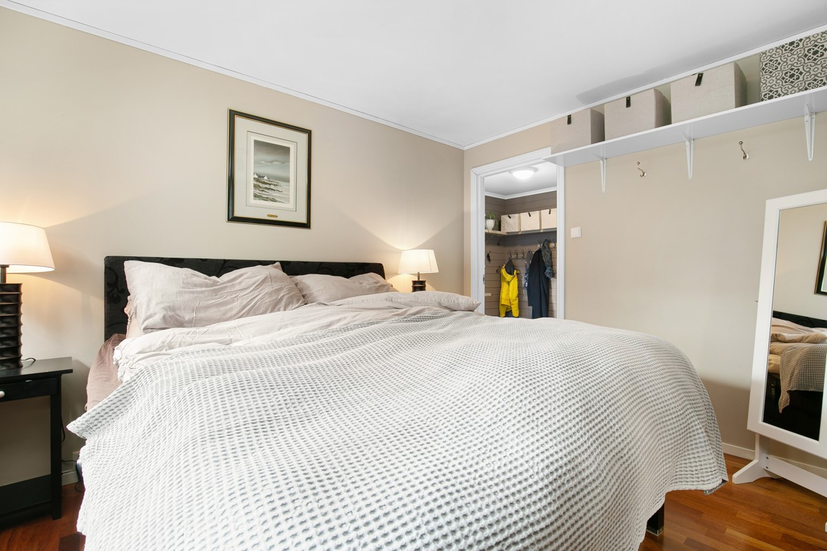 Hovedsoverommet er malt i delikate farger og har plass til stor seng. Her er det også en praktisk skyvedørsgarderobe