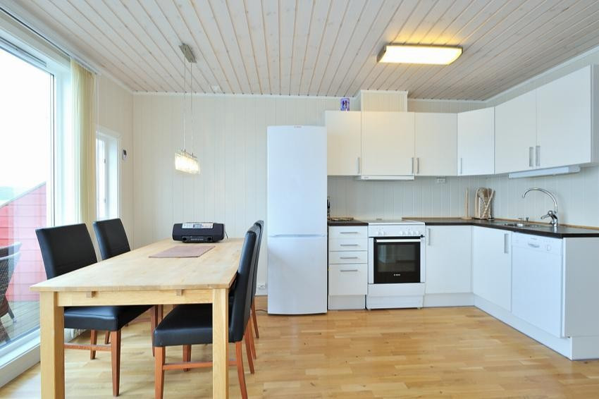 Kjøkken med hvite glatte fronter og opplegg til vaskemaskin