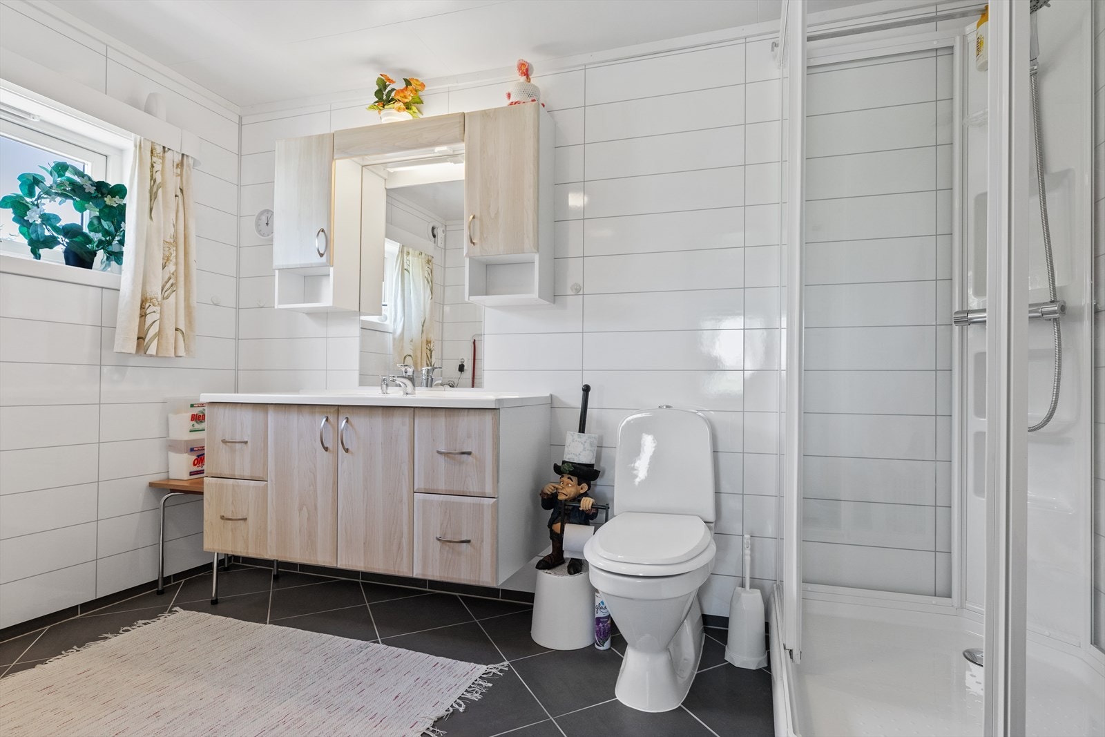 Pent baderom med god oppbevaringsplass og romslig dusjkabinett. Galleribilde