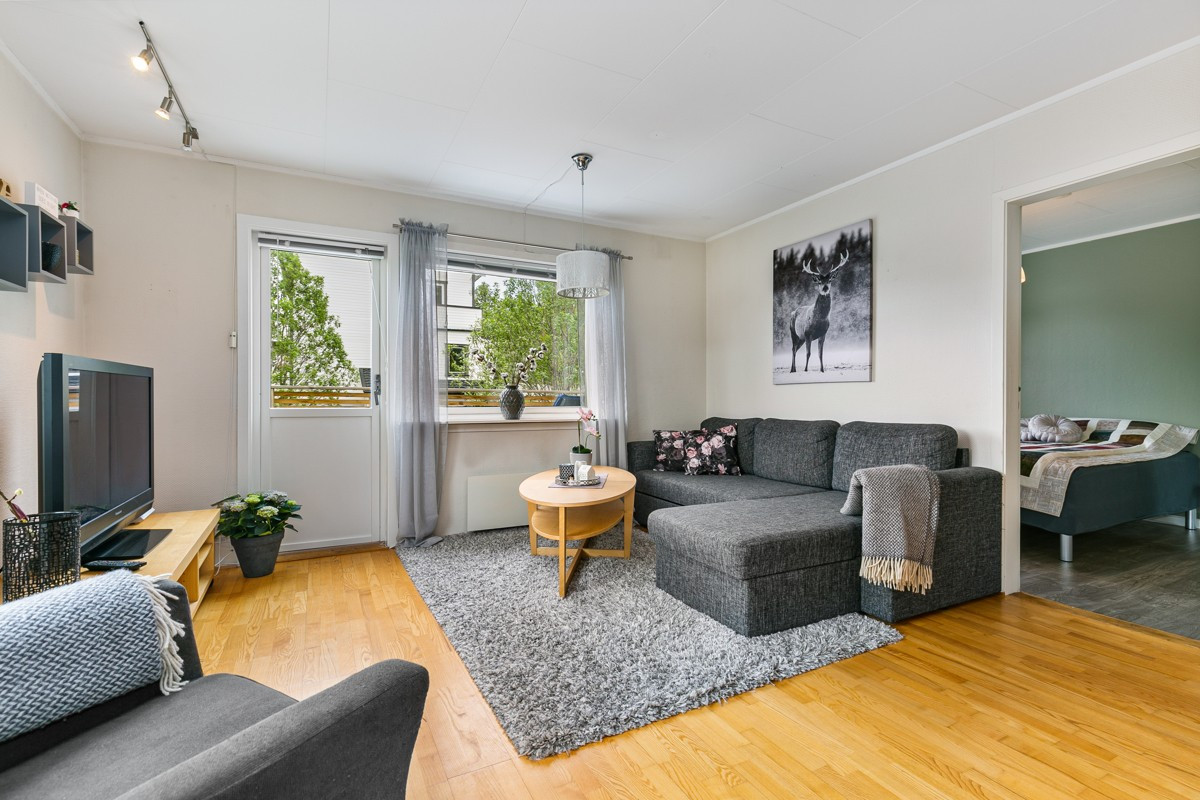 Boligen har en romslig og lys stue med utgang til veranda