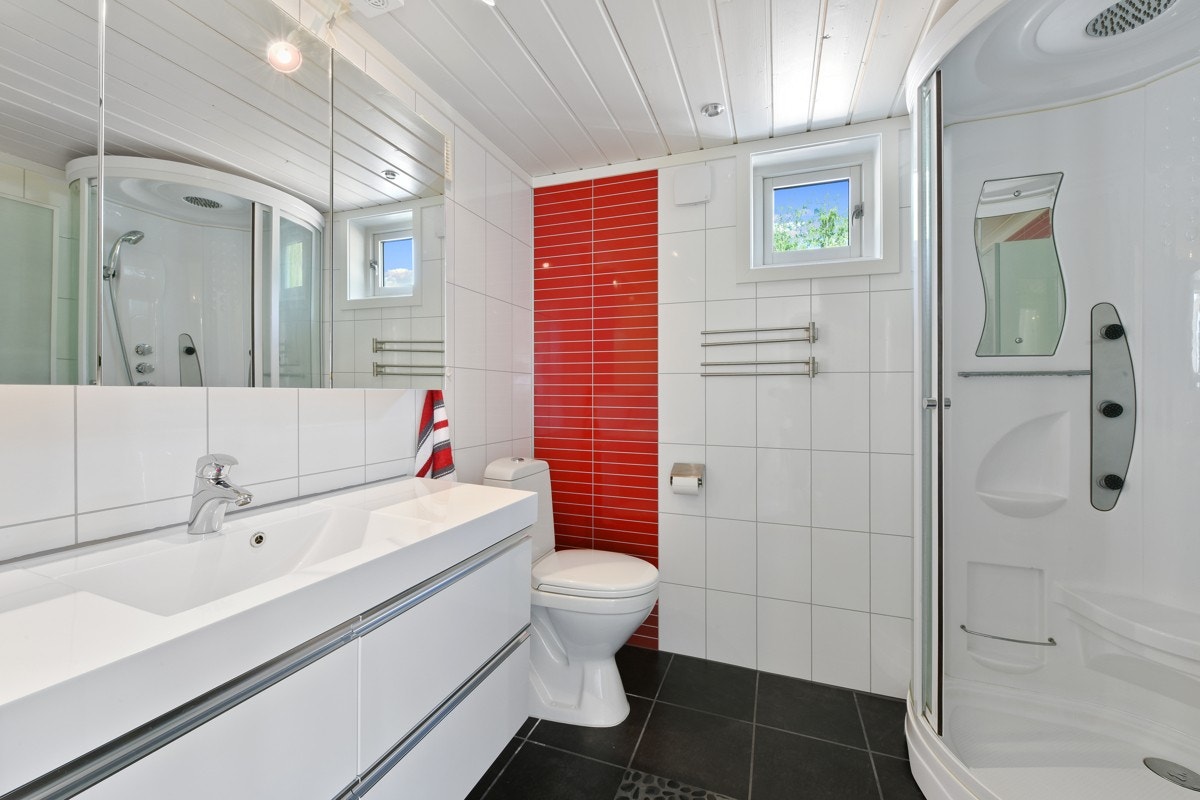 Badet har et delikat preg med flislagt gulv, våtromsplater på vegg, varme i gulvet og downlights i himling. Galleribilde