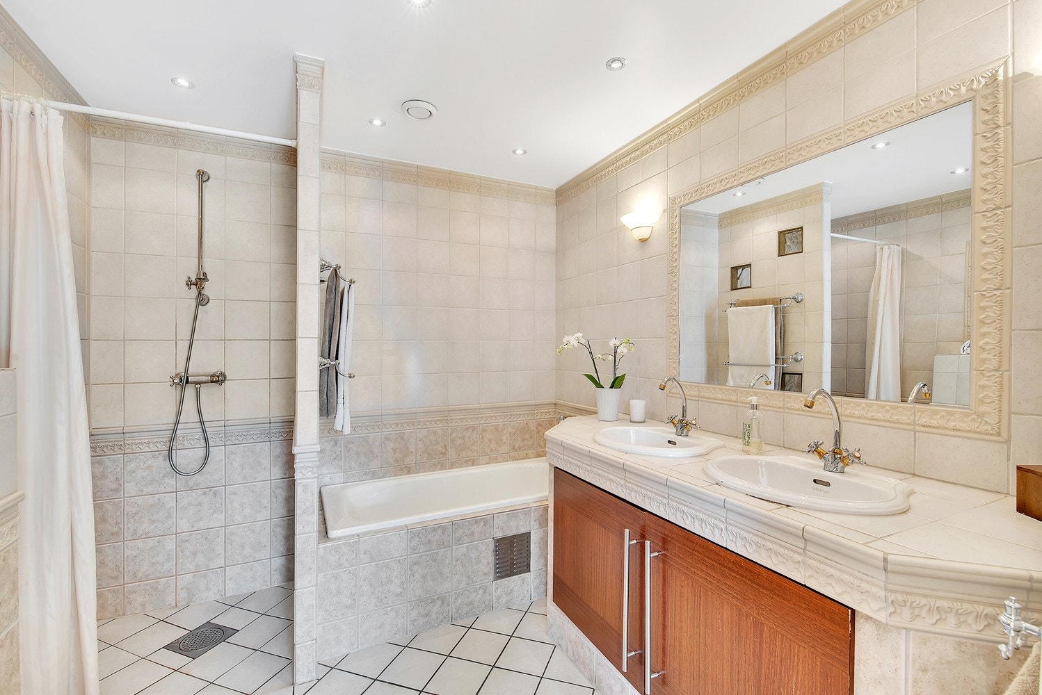 Pent flislagt bad med både dusjhjørne og badekar. Mye skapplass under nedfelt dobbelservant. Galleribilde