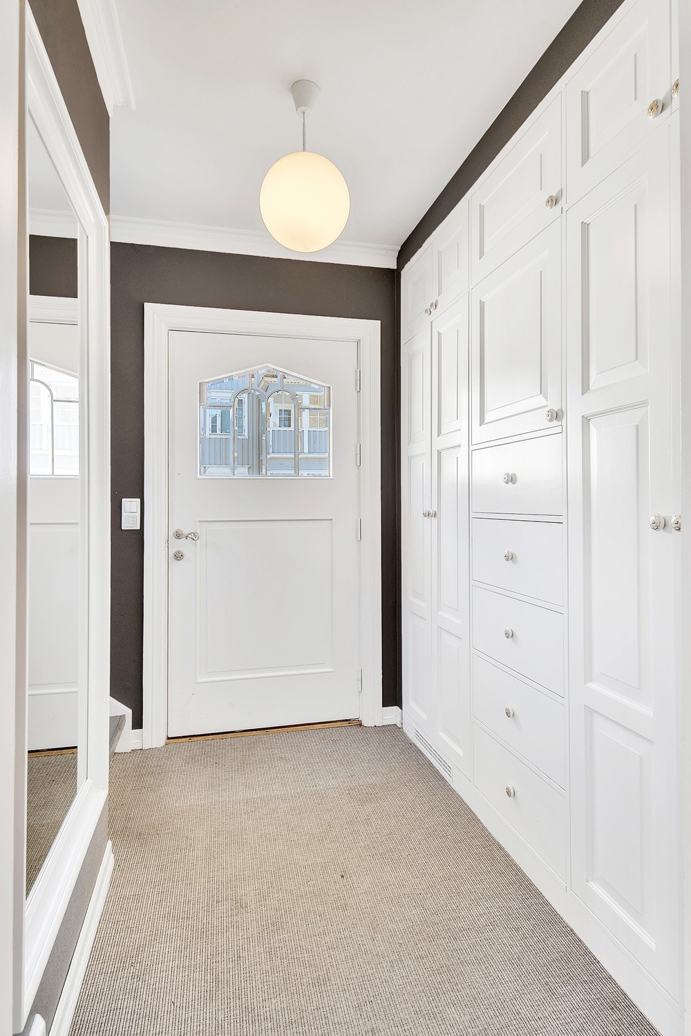 Teppebelagt entrè med stort garderobeskap. Inngang til utleiedelen til høyre når man kommer inn. Galleribilde