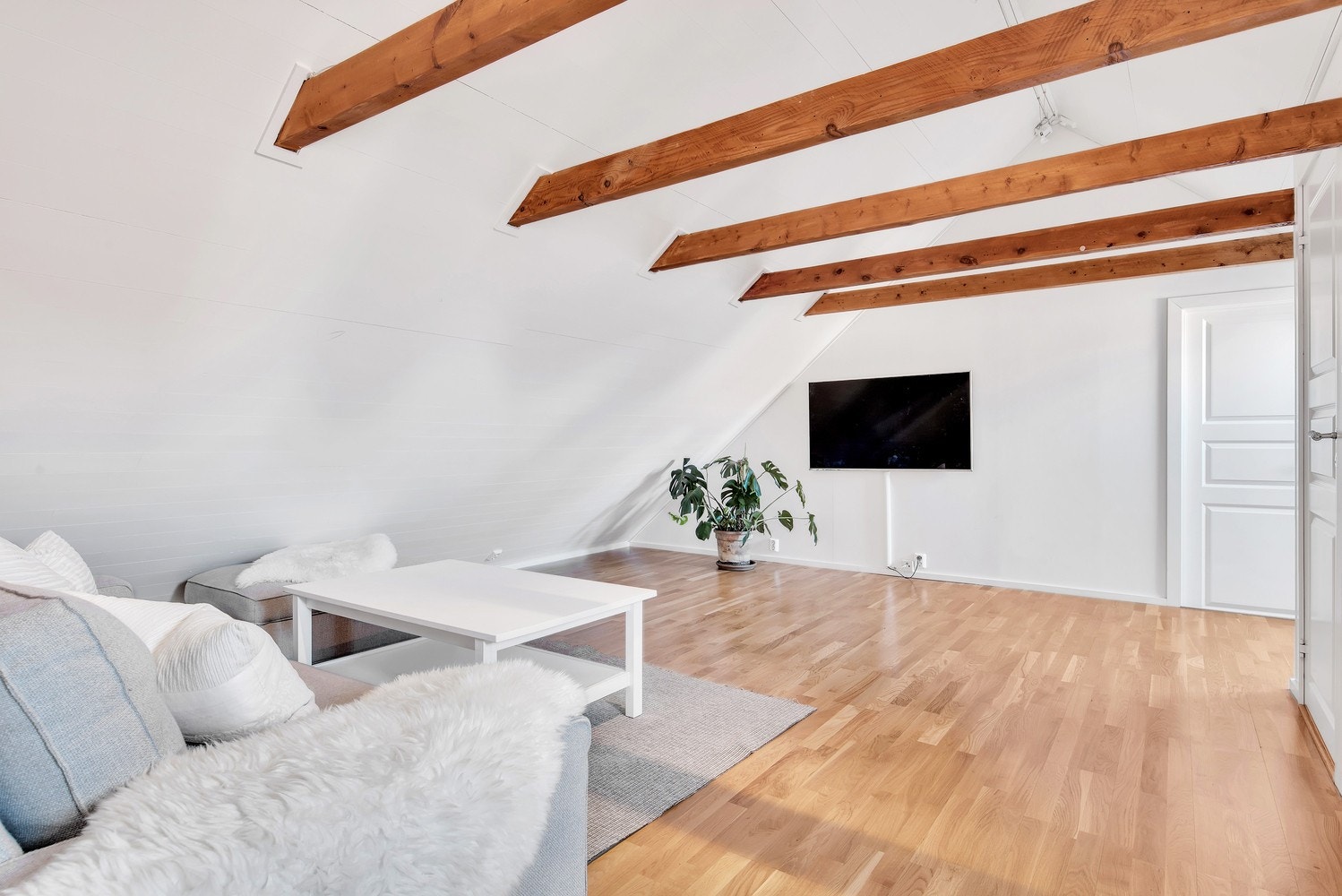 Sjarmerende detaljer med skråtak og bærebjelker i naturfarger. Galleribilde