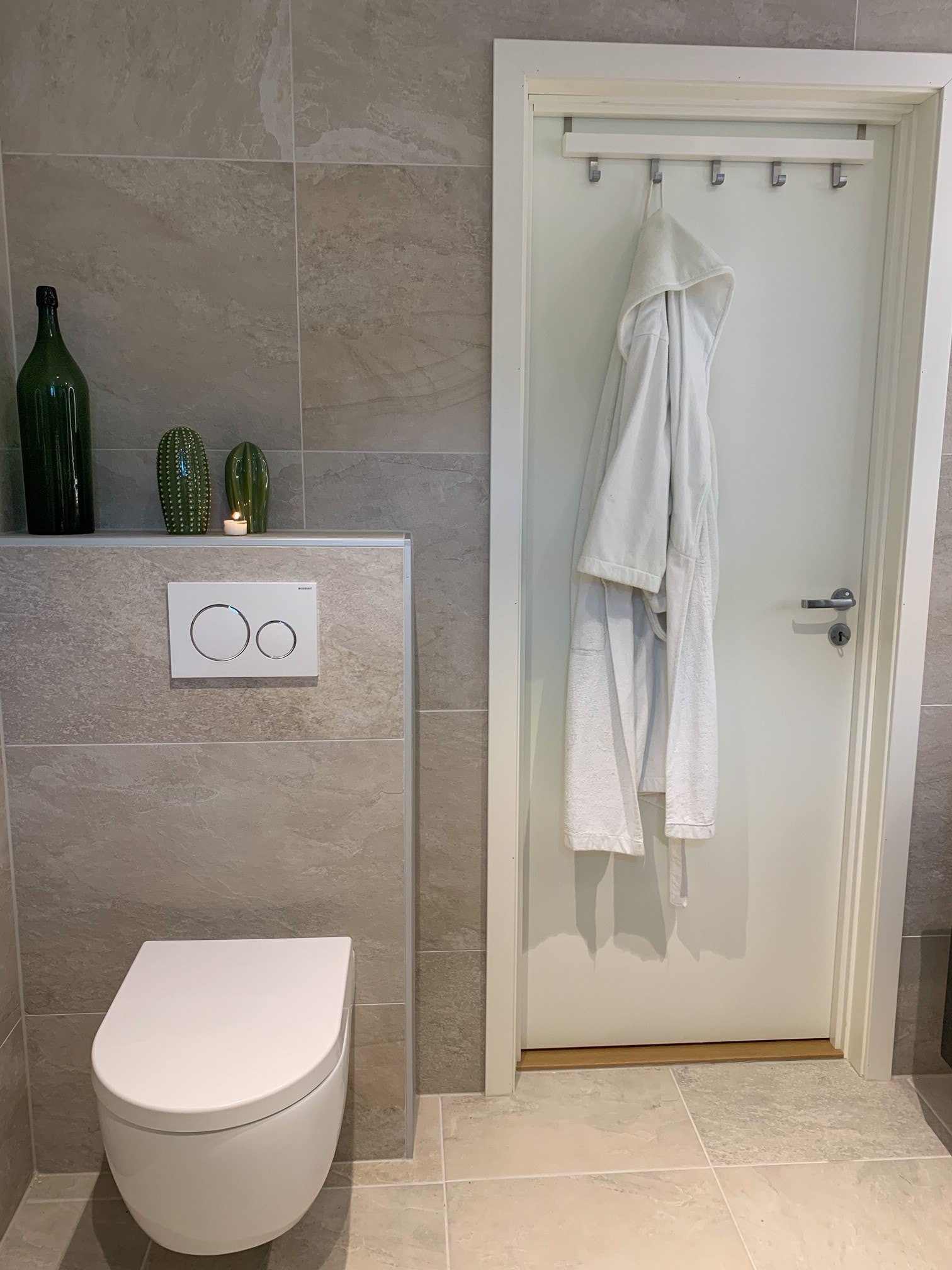 Romslig bad med flislagte vegger og gulv, «rainfall» dusj og vaskemaskin. Galleribilde