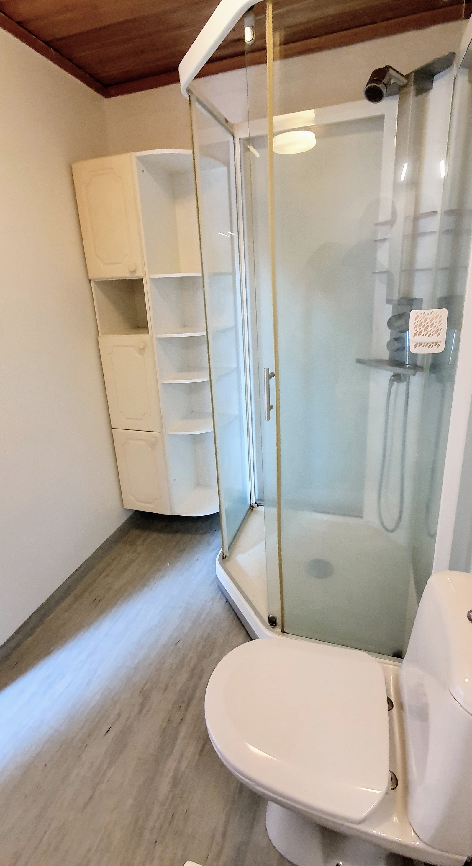 Dusjkabinett på badet, med praktisk høyskap. Galleribilde