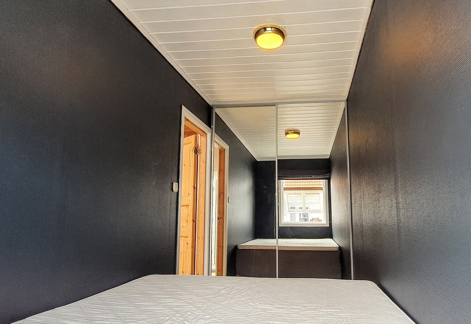 Soverom med dobbeltseng og skyvedørsskap med speil. (Rommet er nå blåmalt, ikke svart som på bildet) Galleribilde