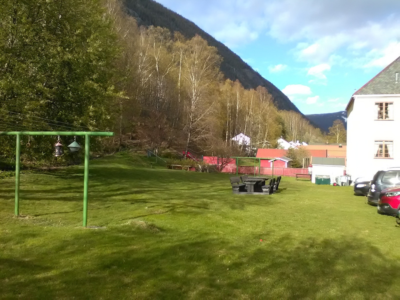 Hage med benker, bord og tørkesnorer Galleribilde