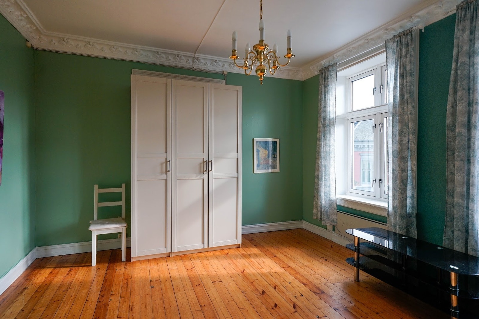 I taket henger en femstakers lysekrone. Galleribilde