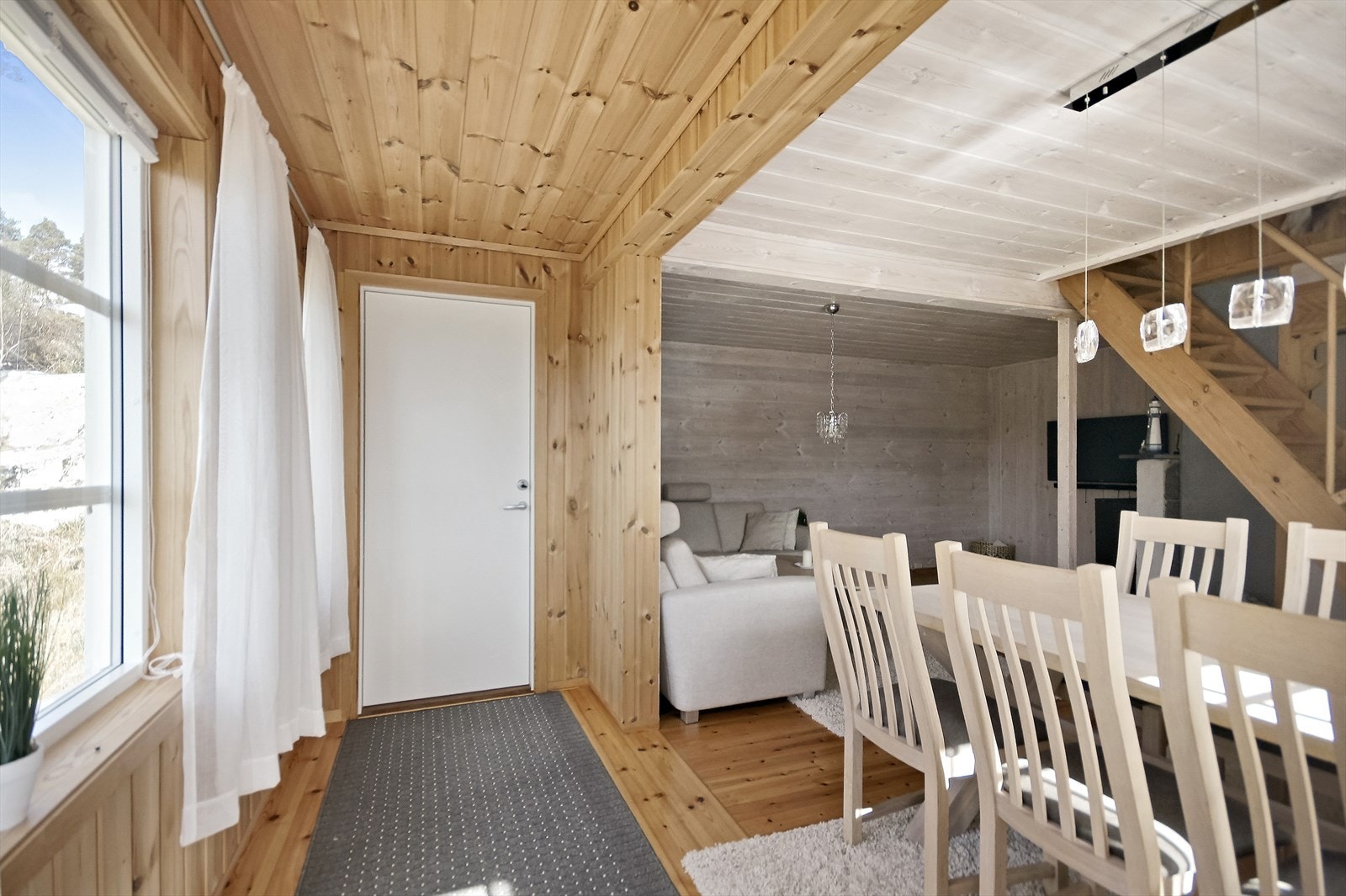 Hytten har eget vindfang der det er plass til å henge fra seg yttertøyet, før du kommer inn i stuen Galleribilde