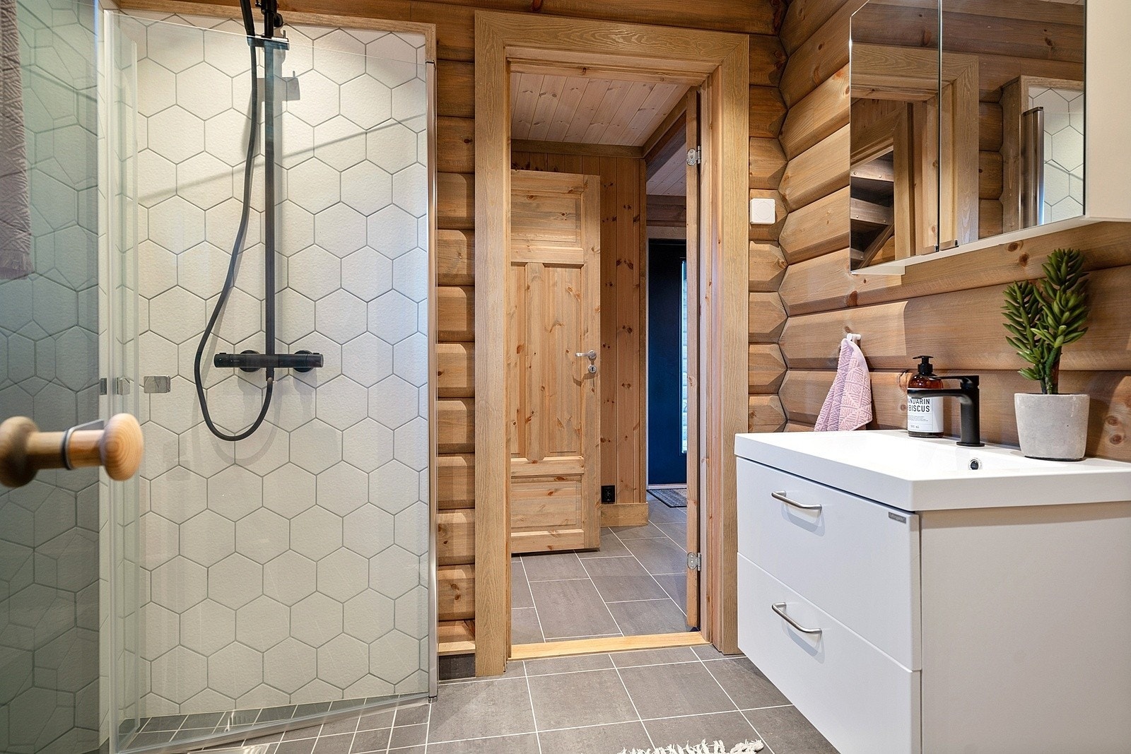 Praktisk bad med fliser i dusjnisje og innredning fra Drømmekjøkkenet og badstue ved siden av. Galleribilde