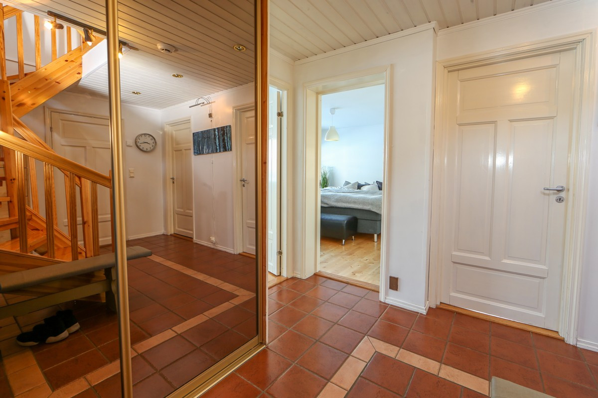 Skyvedørsgarderobe og fliser på gulv i gang