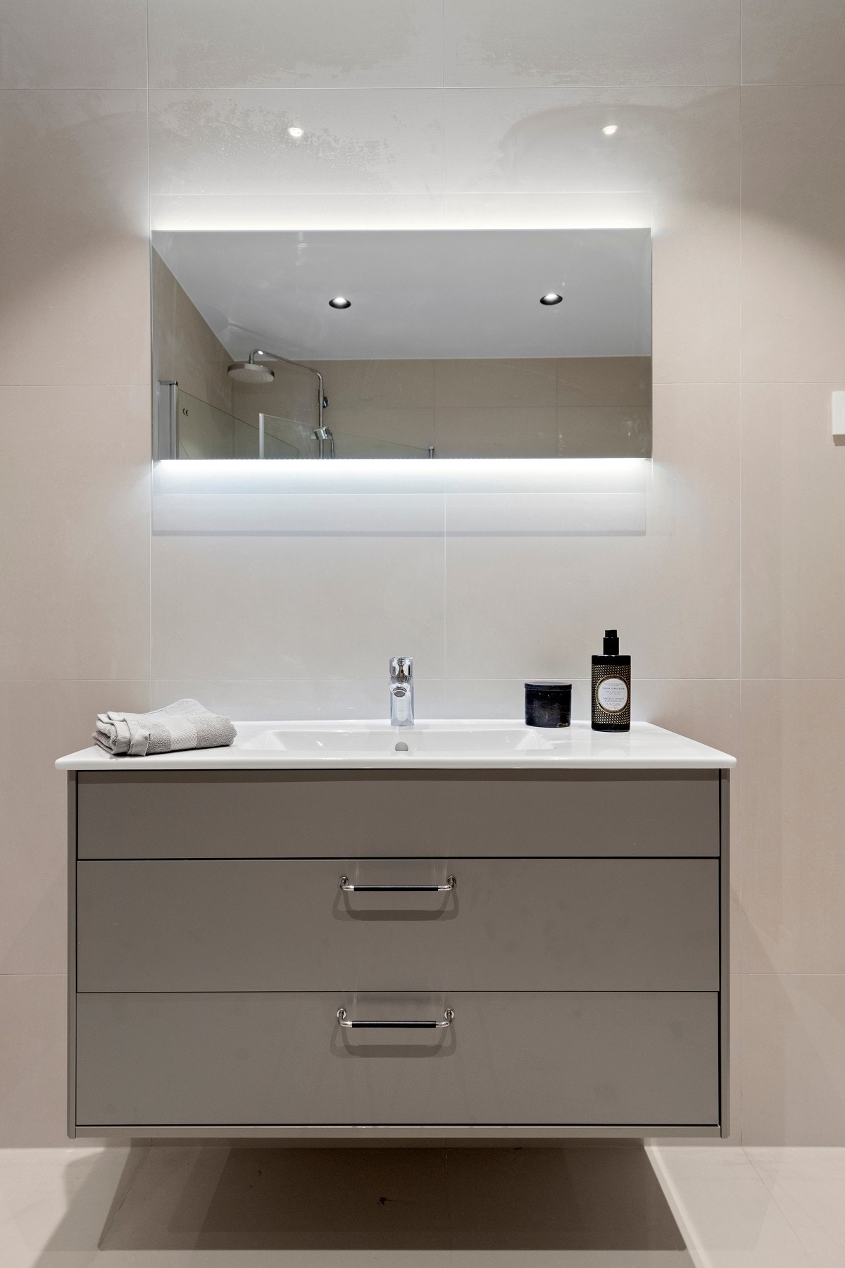 Badet er innredet med dusjnisje, servant med skuffeseksjon og speil med belysning og klosett. Galleribilde