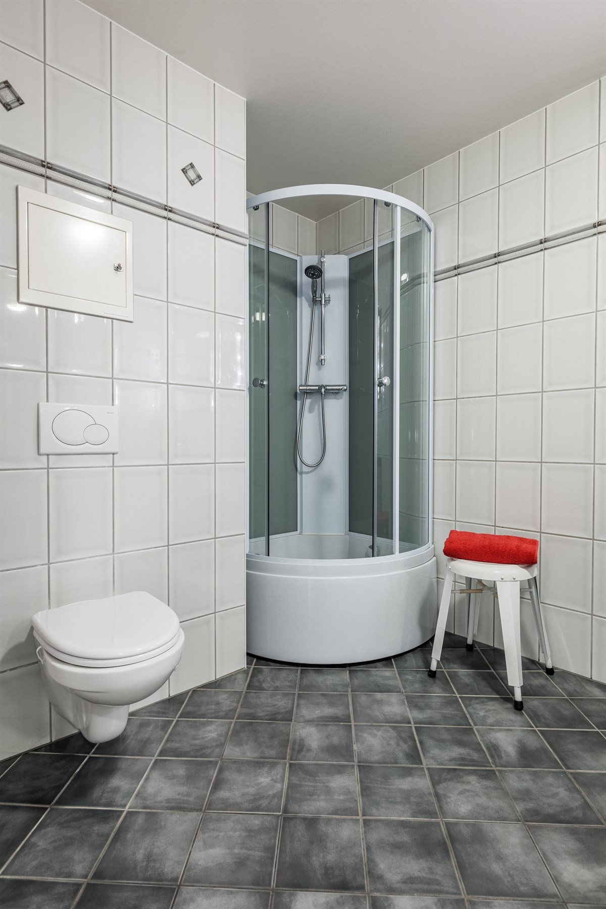 Badet er utstyrt med dusjkabinett med kar