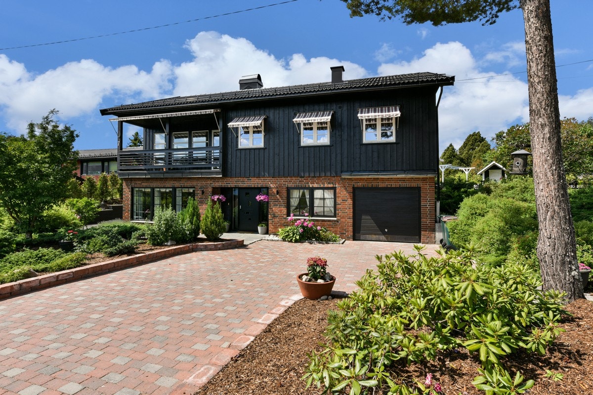 Den romslige tomten er oppgradert og ligger på hjørnet, flott opparbeidet med belegningsstein, skifer og støttemur. Galleribilde