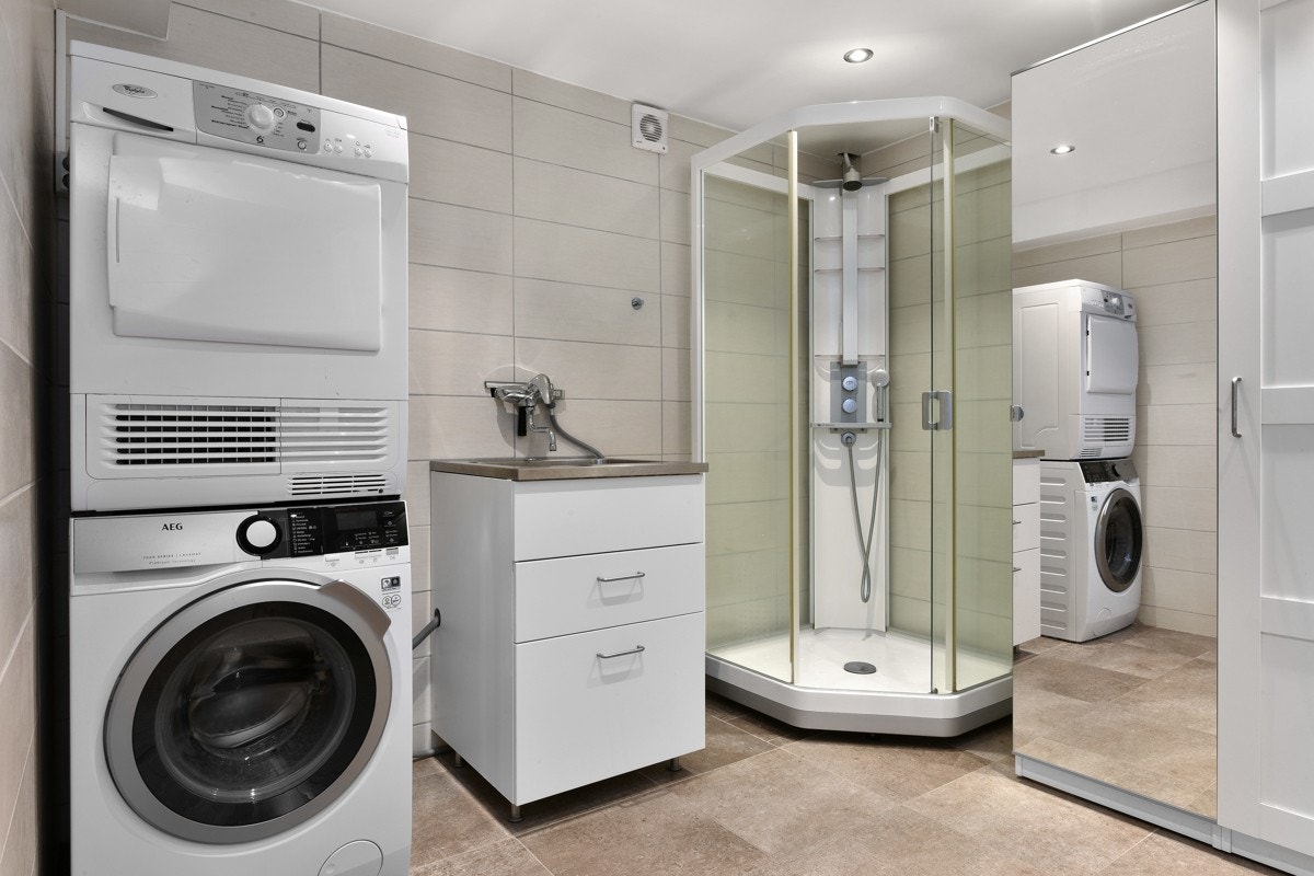 Badet i underetasjen ble oppgradert i 2015 med fliser i beige nyanser, derav mørkere på gulv med gulvvarme, og det er downlights i taket. Rommet har innredning med vaskekum, stort, vinklet garderobeskap, dusjkabinett og opplegg for vaskesøyle. Galleribilde