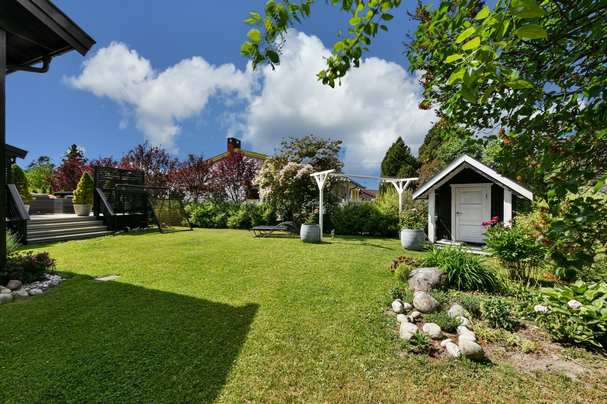 Hagen ligger inngjerdet, her er det vakkert med "fløyels plen", heller, blomsterbed, naturstein og frodige vekster. Galleribilde