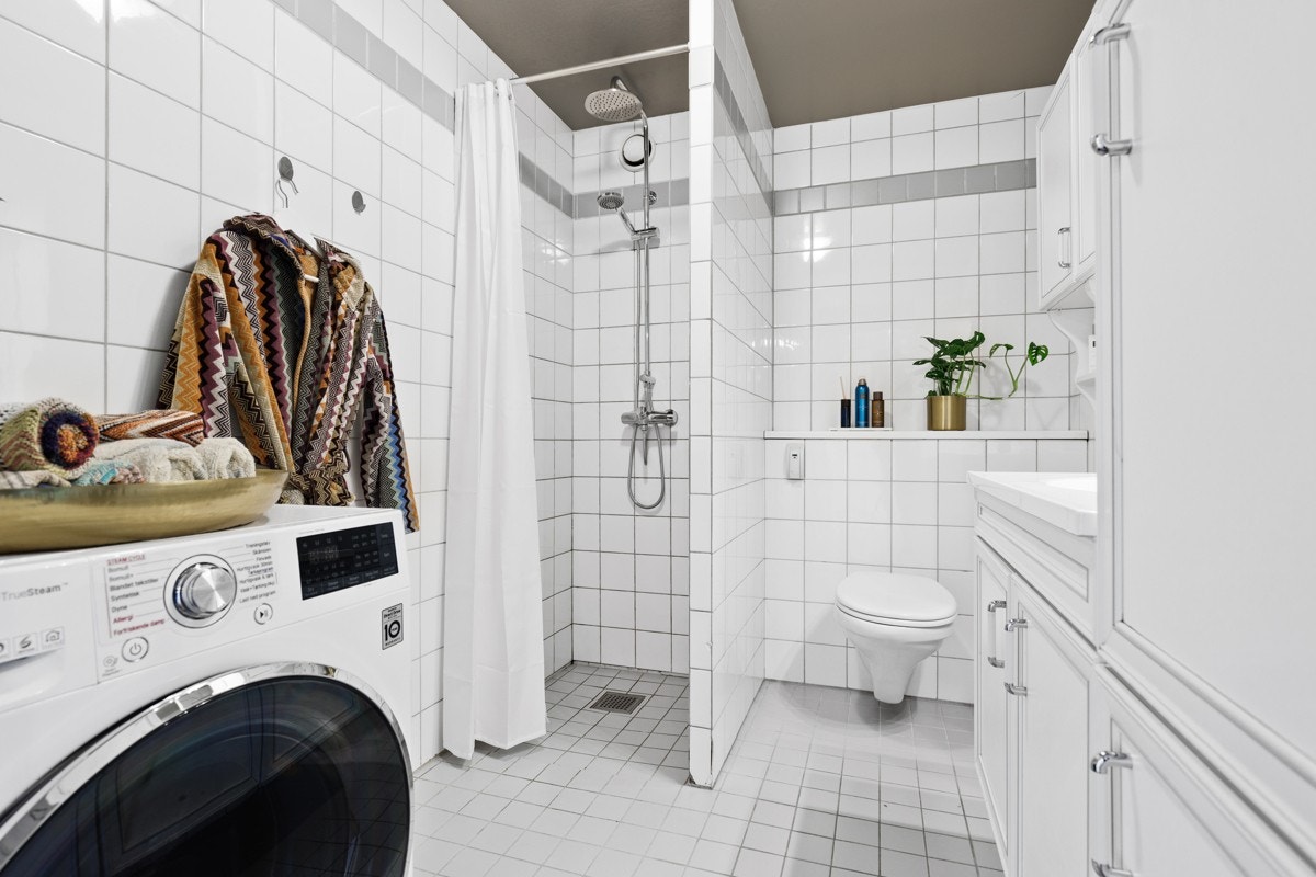 Flislagt baderom med opplegg for vaskemaskin. Galleribilde