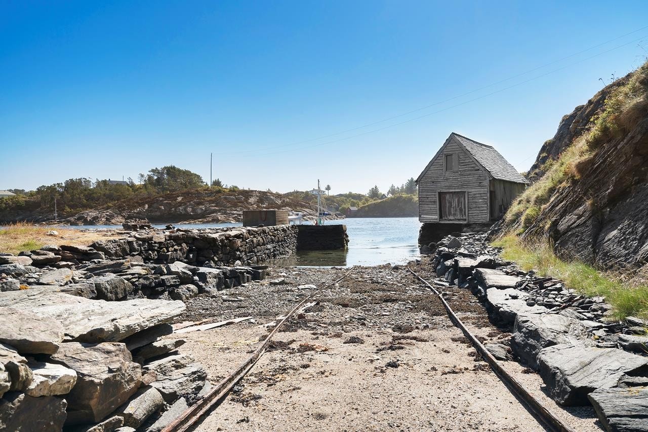Dypvannskai i naturstein og stort naust Galleribilde