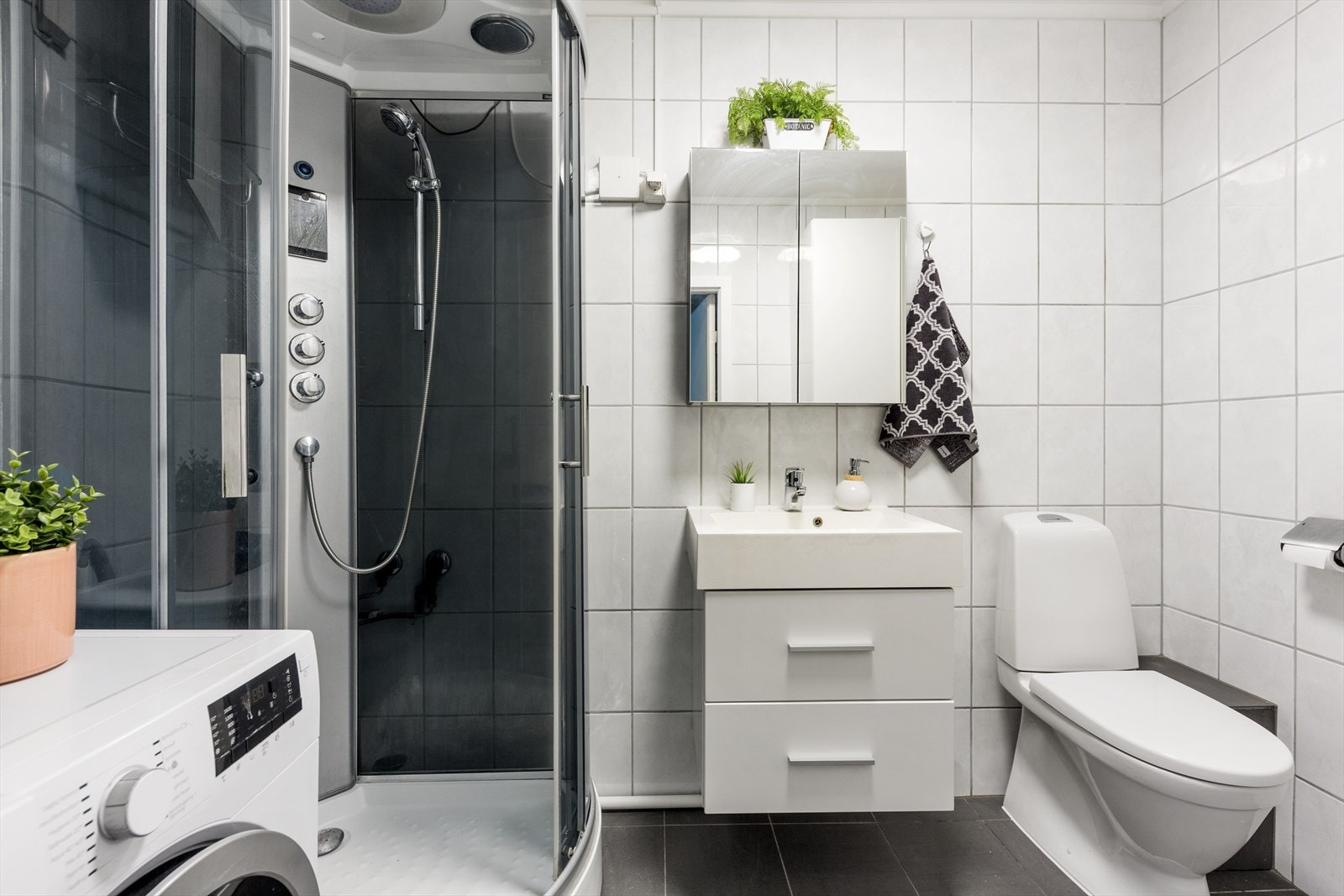 Baderommet har adkomst fra stuen og er utstyrt med servantsinnredning, dusjkabinett og gulvstående WC. Galleribilde