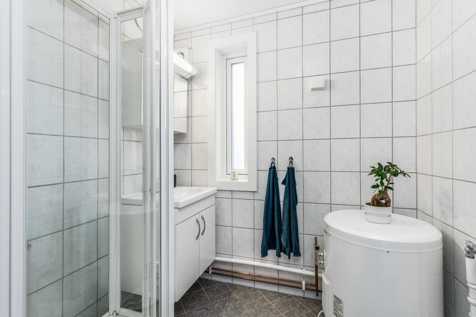 Innredning med lagringsplass, dusjkabinett og opplegg for vaskemaskin. Galleribilde