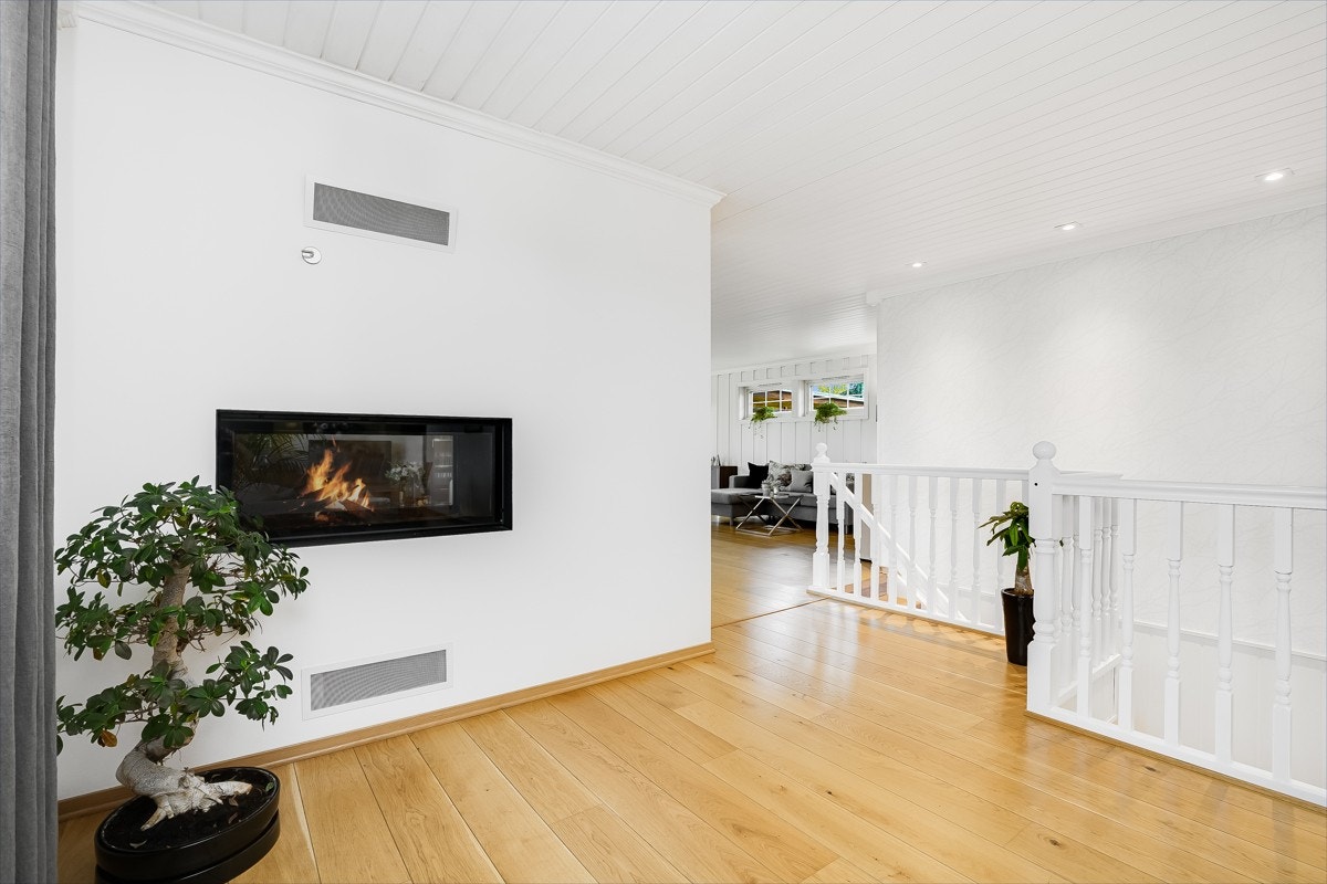 Gulvet har enstavs parkett, med unntak av et flissatt felt ved ildstedet, og veggene er i tidsmessig grått, kombinert med panel. Galleribilde