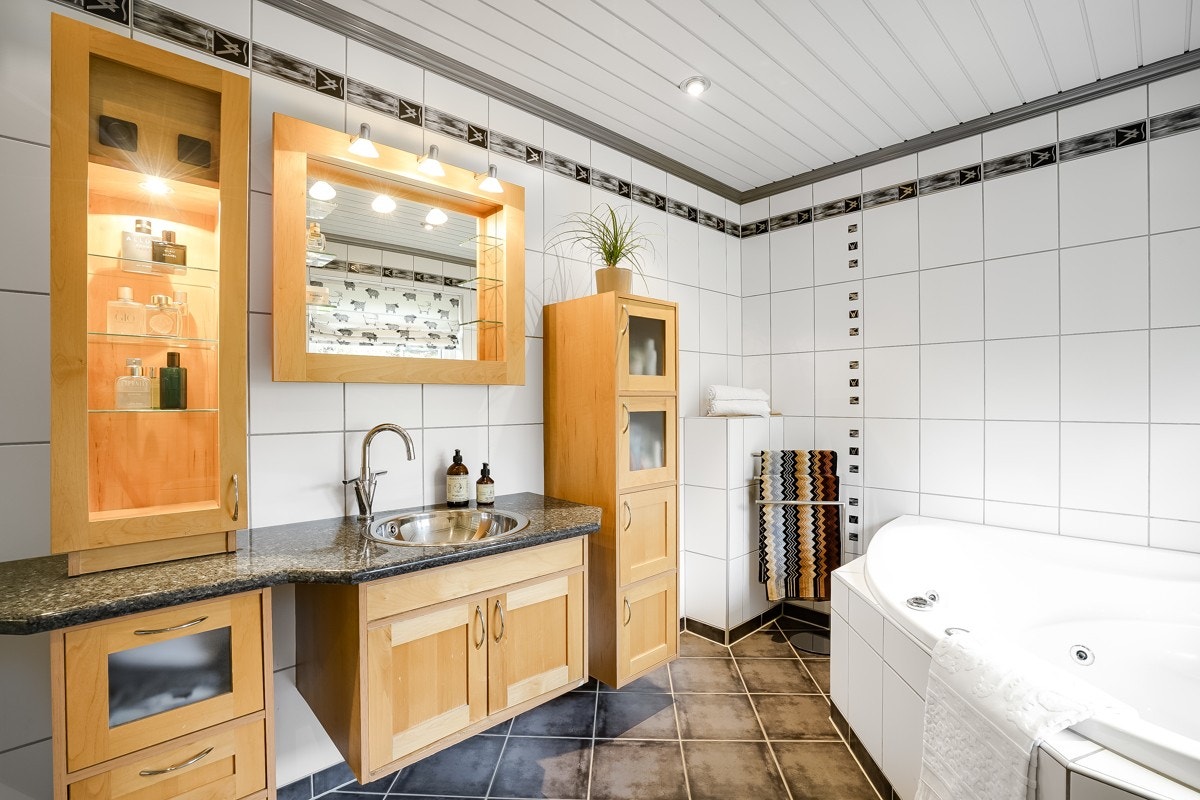 Badet i 2.etg har velholdte fliser i hvitt og grått, felt i vegg med glassbyggerstein og downlights i tak. Galleribilde