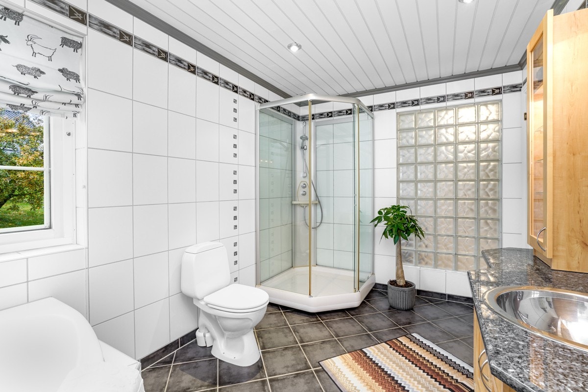 Det er ellers utstyrt med toalett, dusjkabinett og et innfliset hjørnebadekar. Galleribilde