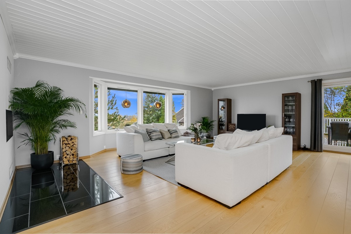 Karnapp og store vinduer til gulvet fyller rommet med lys og det er skyvedør til terrasse. Galleribilde