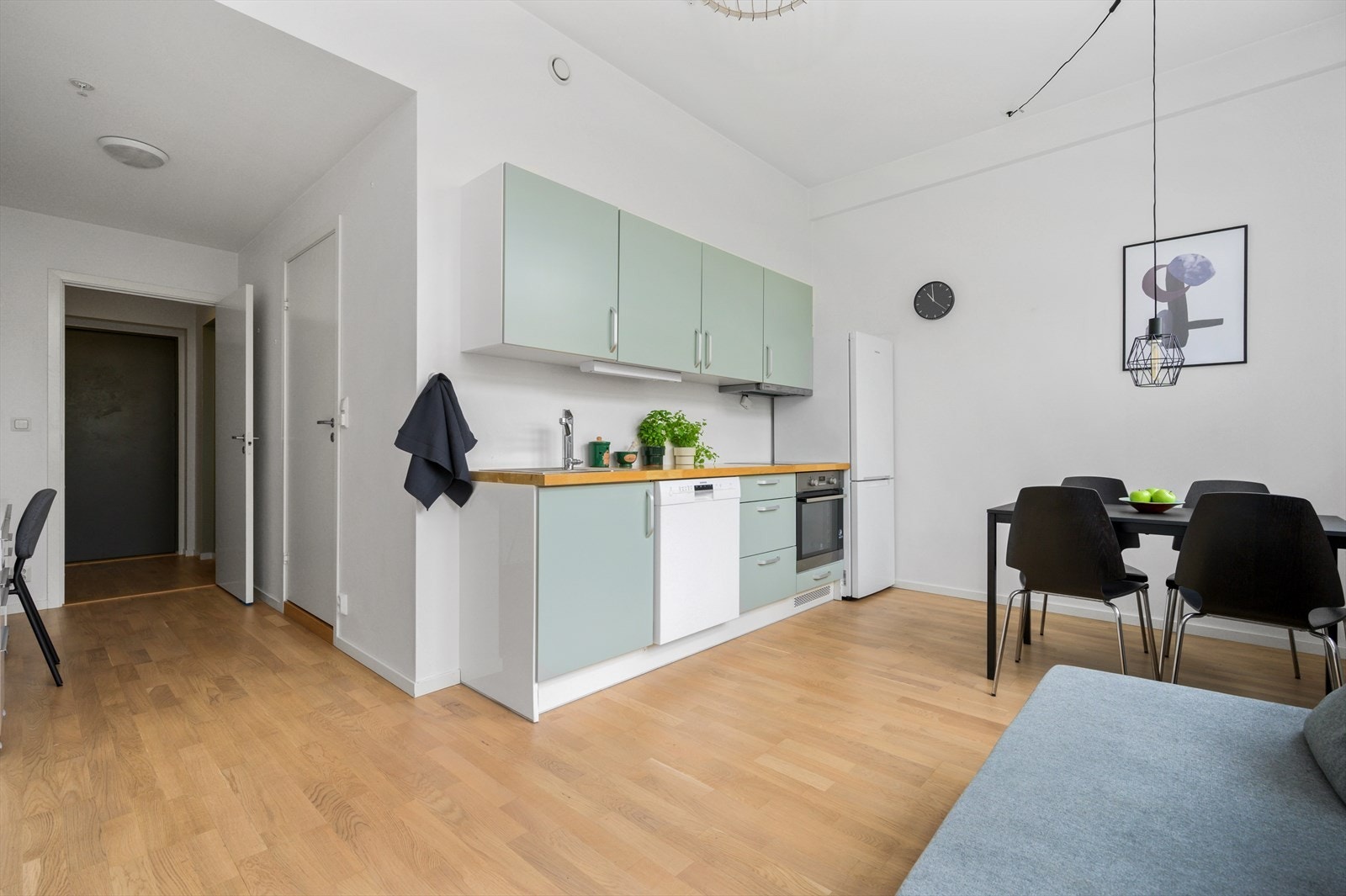 Kjøkkeninnredning med glatte fronter, heltre benkeplate med nedfelt kum i rustfritt stål, kullfilterventilator, stekeovn og keramisk topp er integrert i innredningen, automatisk vannstopper tilknyttet oppvaskmaskin er montert og komfyrvakt Galleribilde