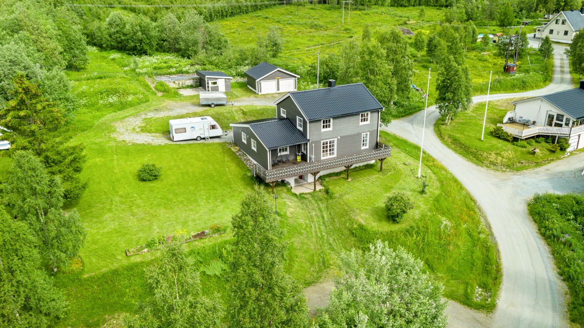 Eiendommen ligger på en pent opparbeidet tomt med plen, prydbusker og trær