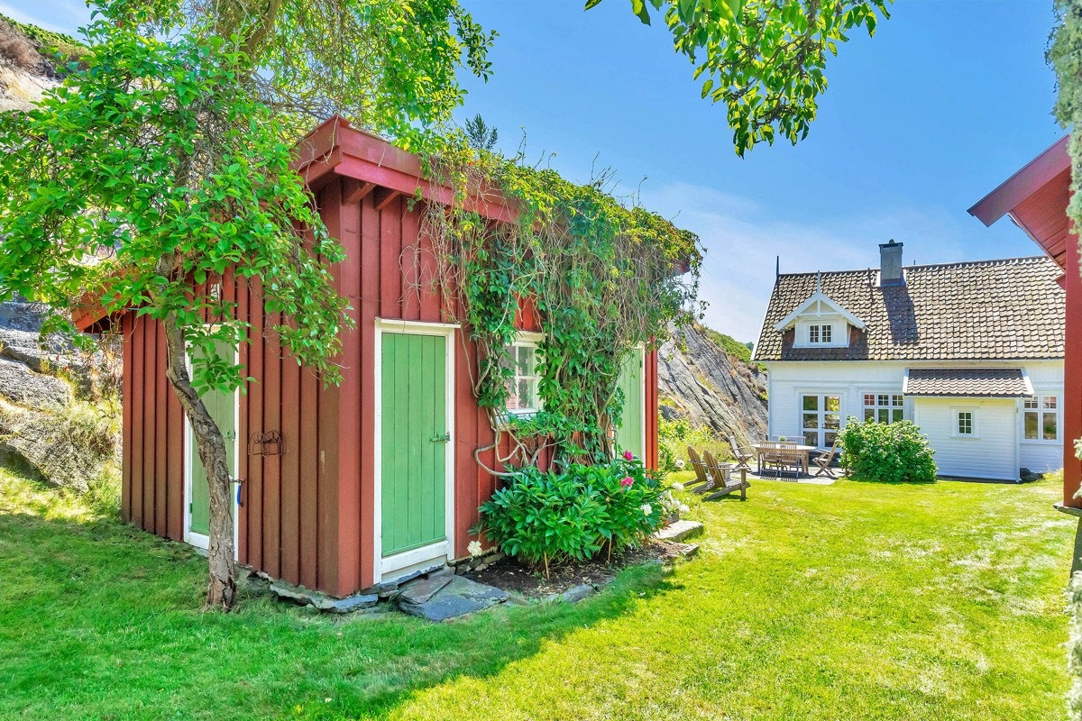 Sjarmerende anneks med rom og boder - og eføy som vokser på vegg og over tak Galleribilde