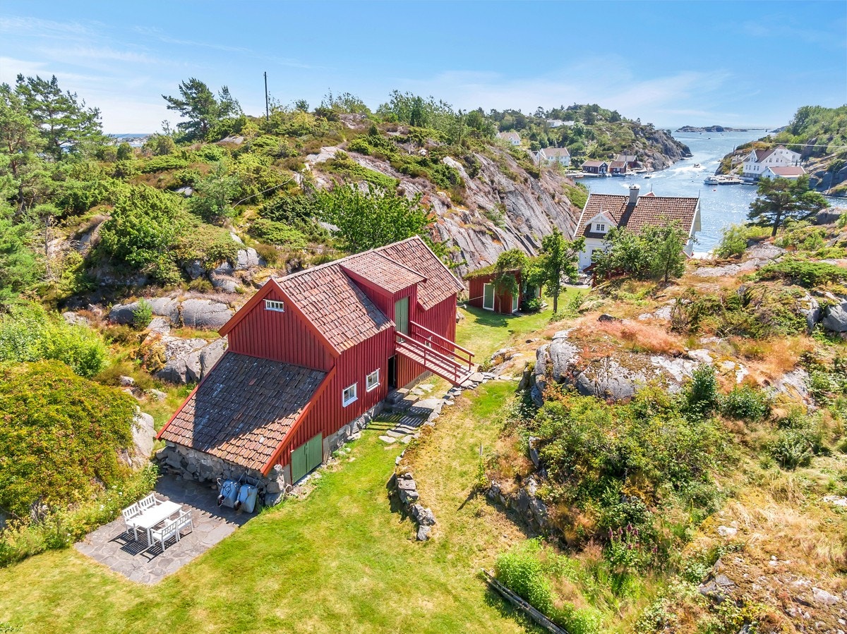 Dronefoto over del av eiendommen med låvebygningen og del av plenanlegget Galleribilde