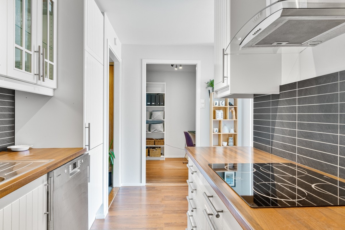 Kjøkkenet er utstyrt med integrerte hvitevarer som stekeovn, keramisk koketopp og kjøleskap med fryser Galleribilde