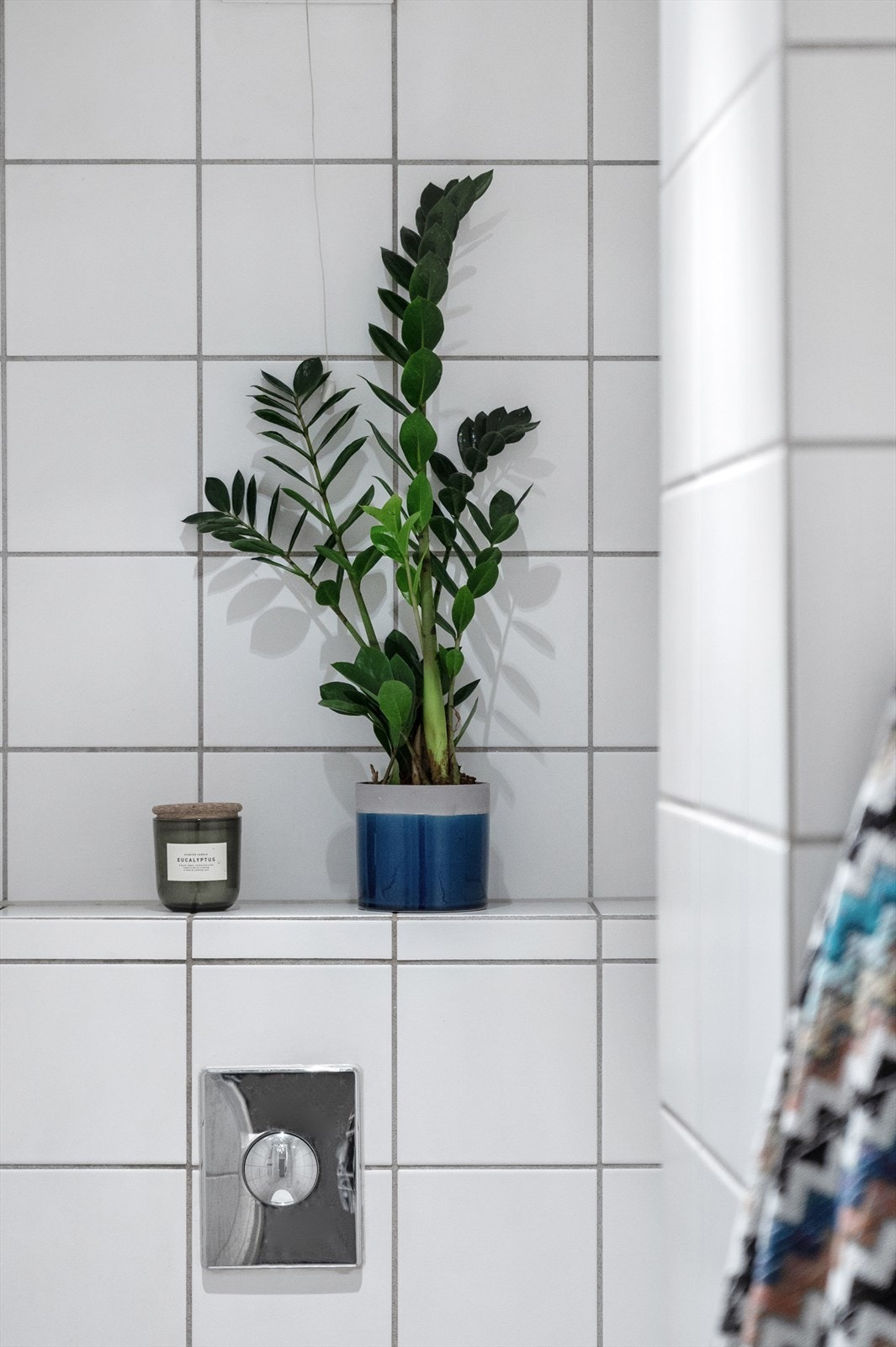 Dusj på gulv, servant i helstøpt plate og veggfestet klosett med innebygget sisterne - baderomsinnredning bestående av benkeskap med glatte fronter - speil og belysning over servant Galleribilde