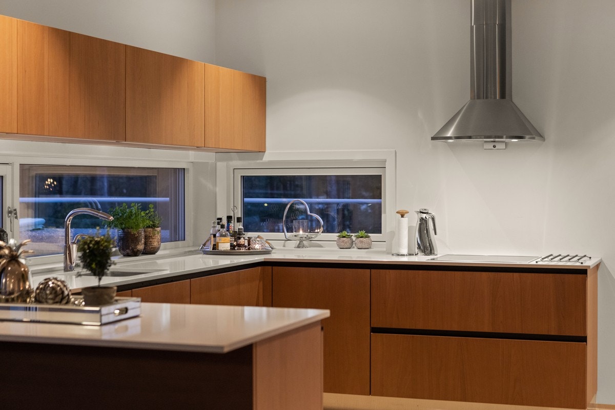 Kjøkkeninnredning fra kvalitetsleverandøren Drømmekjøkken med glatte fronter i valnøtt, benkeplater i granitt og integrerte hvitevarer fra Miele. Galleribilde