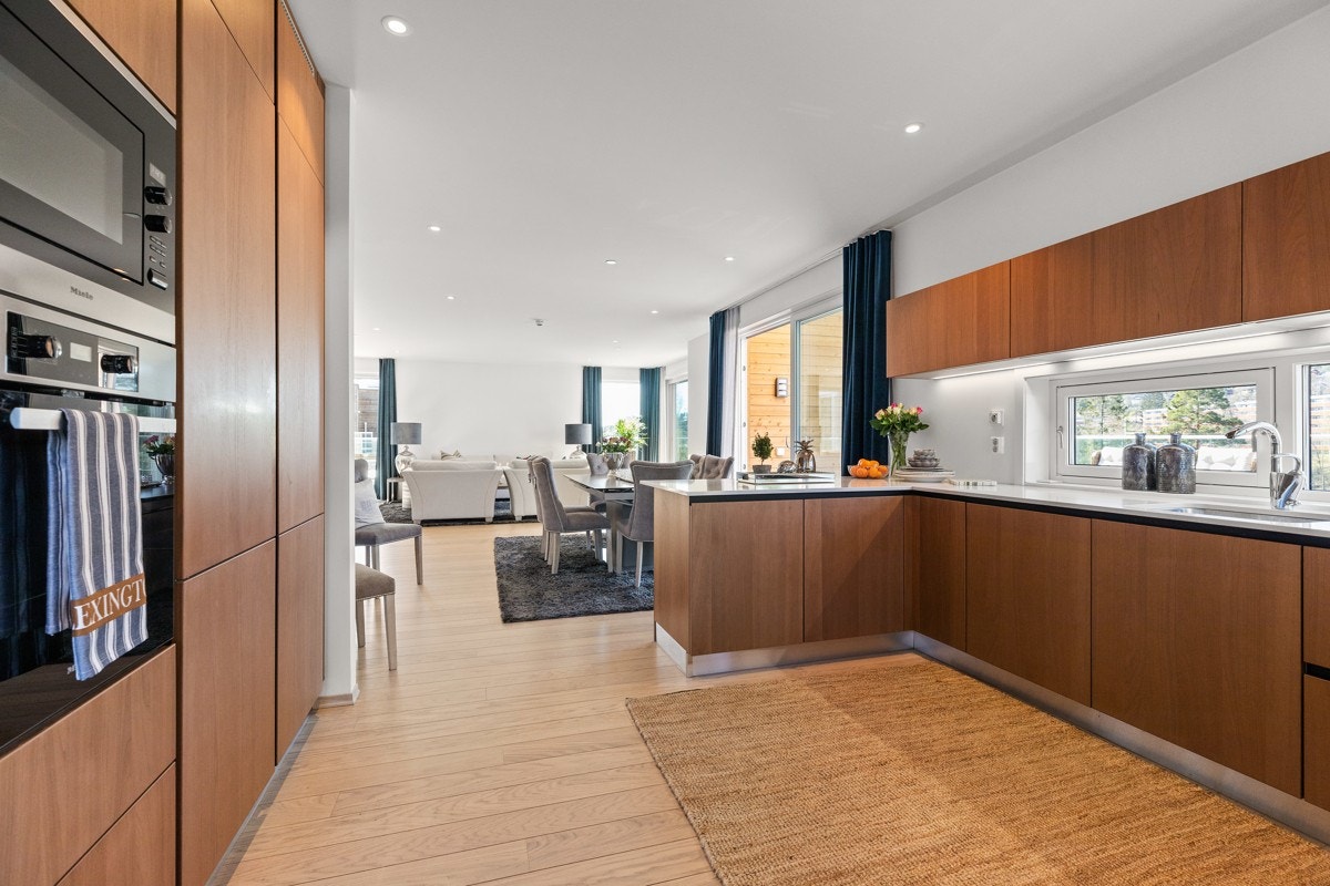 Kjøleskap, fryseskap, komfyr og mikrobølgeovn er integrert i høyskap. Galleribilde