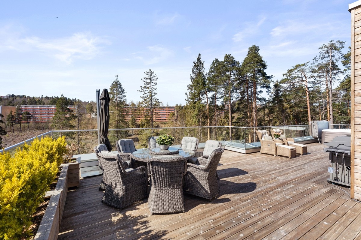 Terrassen har terrassebord i rillet impregnert tre og glassrekkverk. Galleribilde