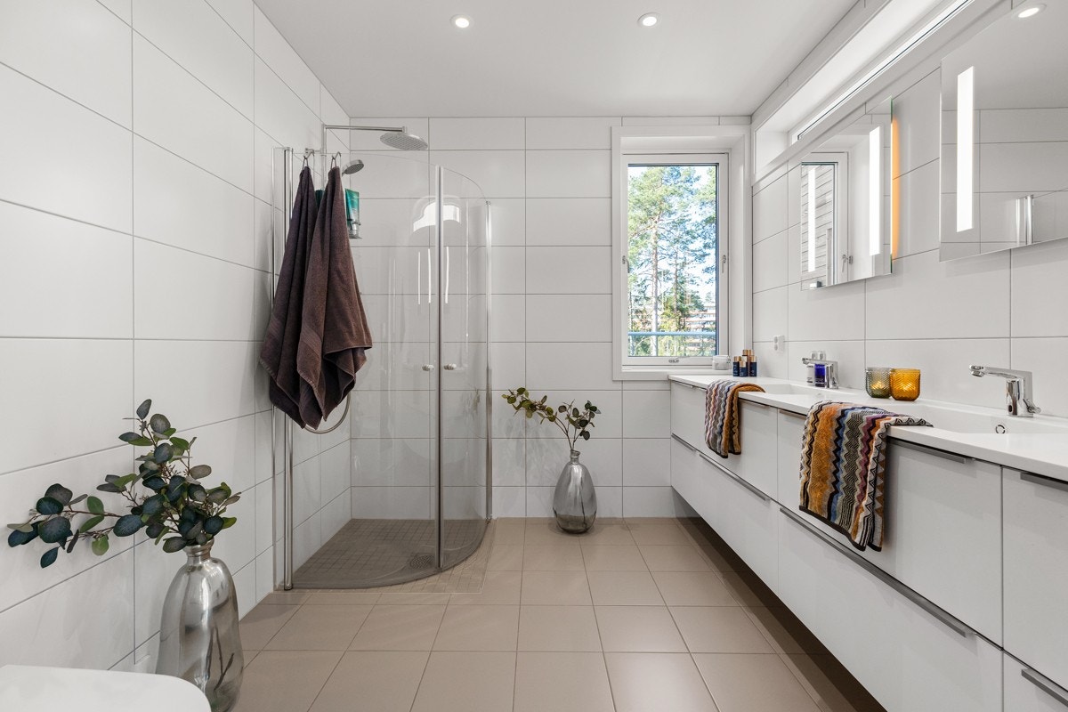 Stort, delikat og helfliset bad med varmekabler i gulv og downlights i himling. Galleribilde