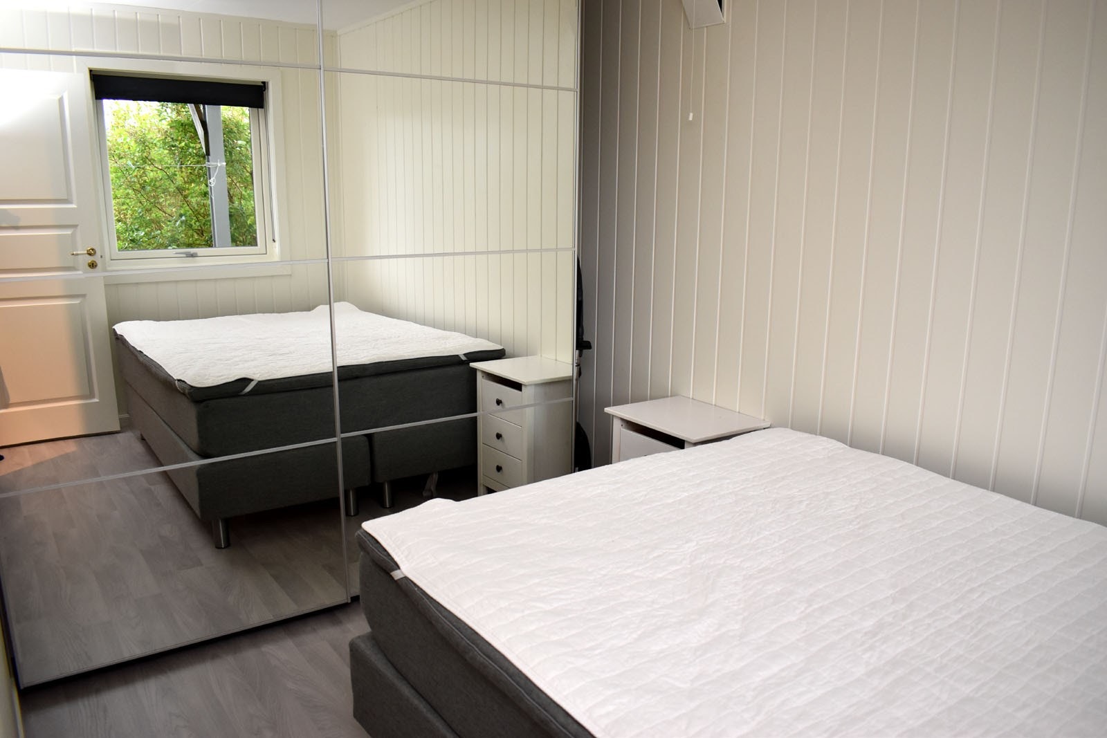 Lyst soverom med ny seng og stort garderobeskap Galleribilde