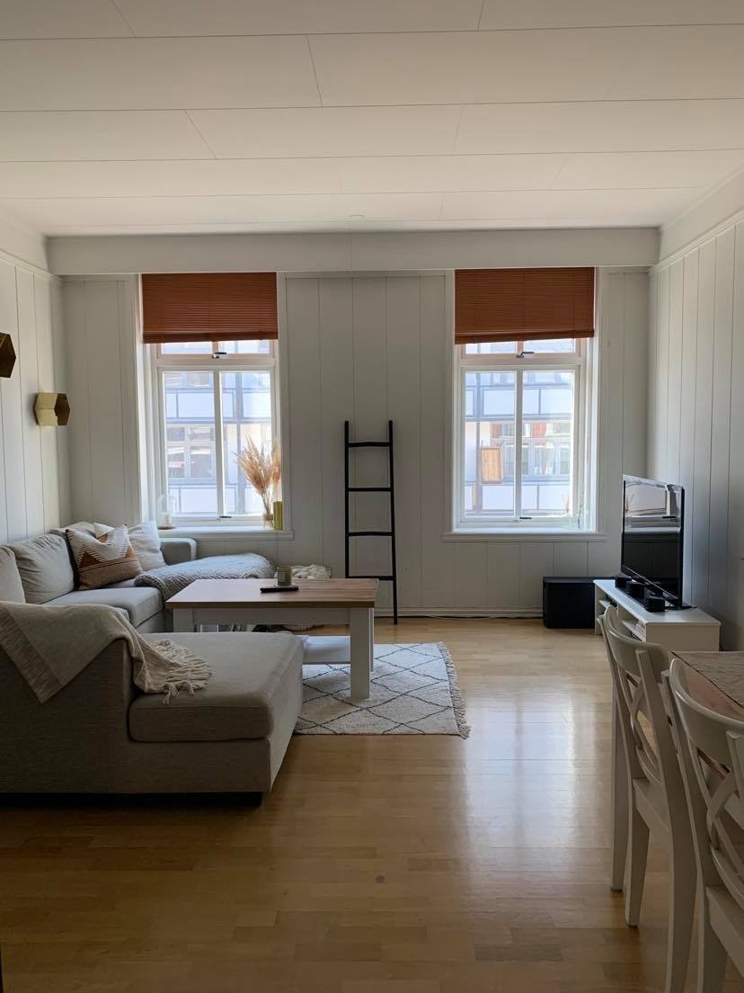 Romslig stue med plass til spisegruppe og hjørnesofa. Peisen er ikke i bruk. Galleribilde