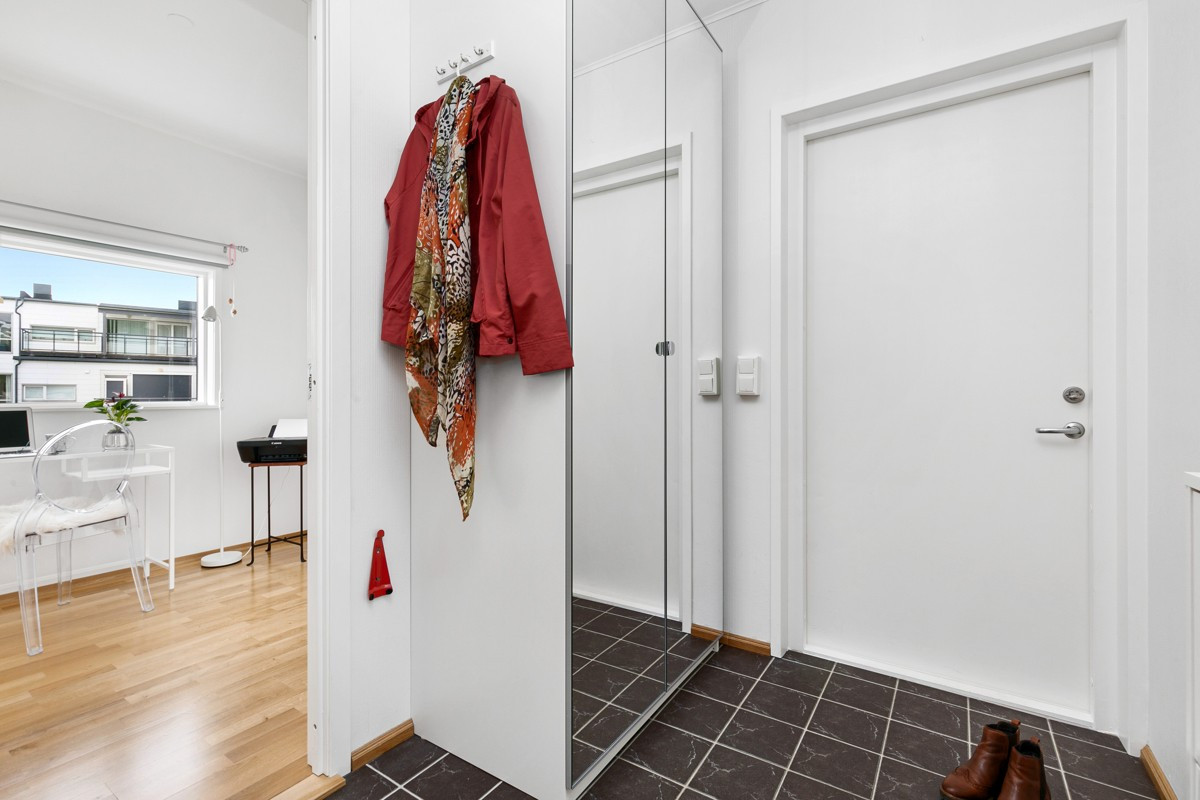 Flislagt entré med gulvvarme - Skyvedørsgarderobe med gode muligheter for oppheng og lagring. For øvrig er det adkomst med heis rett opp i leiligheten fra garasjeannlegget