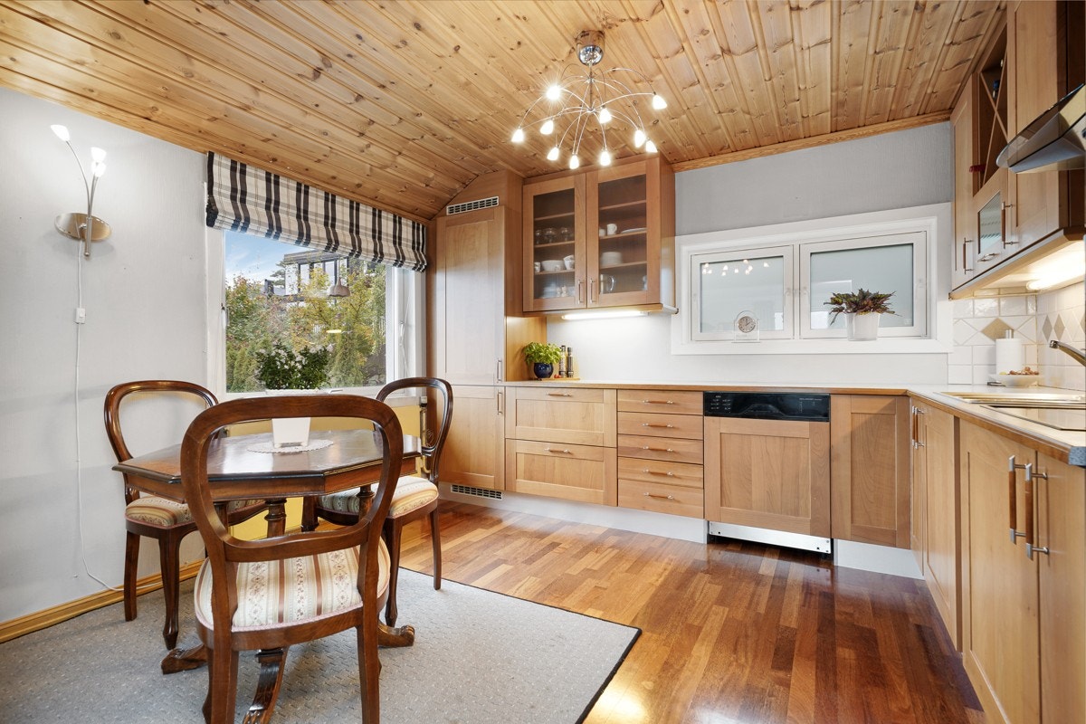 Leilighet - Et pent HTH-kjøkken fra 2001 med profilerte fronter, vitrineskap og benkeplate i laminat med nedfelt oppvaskkum. Galleribilde