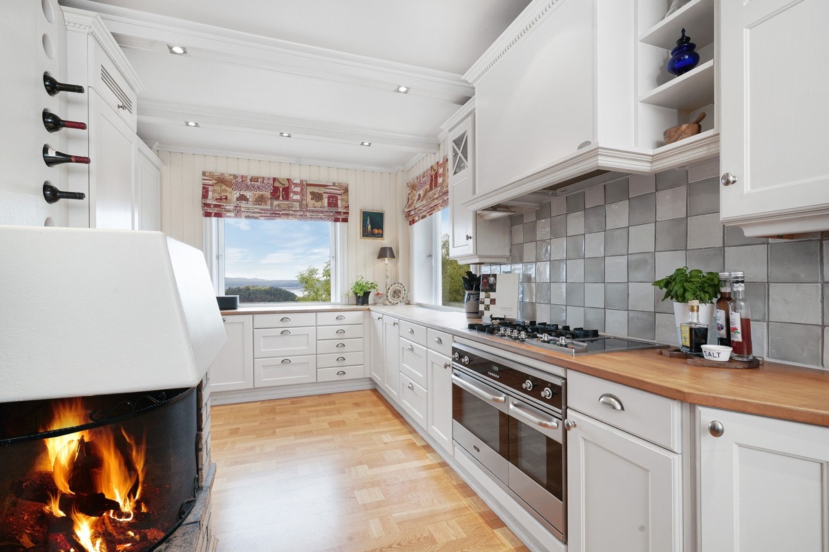 Hovedboligen har et svært sjarmerende kjøkkenrom med peis. Galleribilde