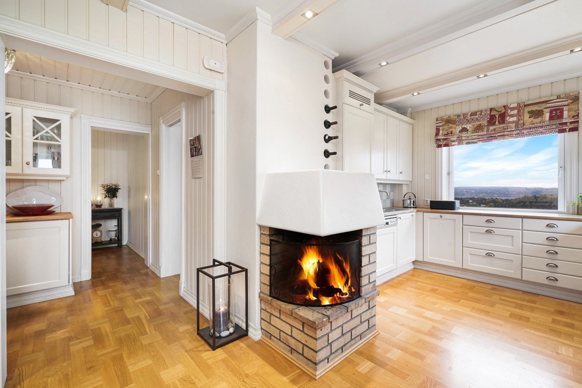 Selve kjøkkenet har klassisk hvit innredning fra Sivesind i hvitlasert heltre eik med profilerte fronter, vitrineskap og heltre benkeplate med nedfelt oppvaskkum. Galleribilde