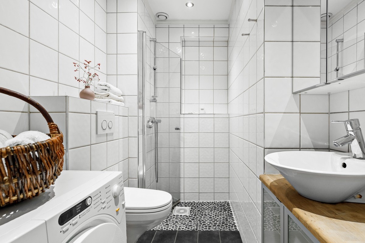 Badet byr på et romslig dushjørne, skap med servant samt vegghengt toalett. Galleribilde