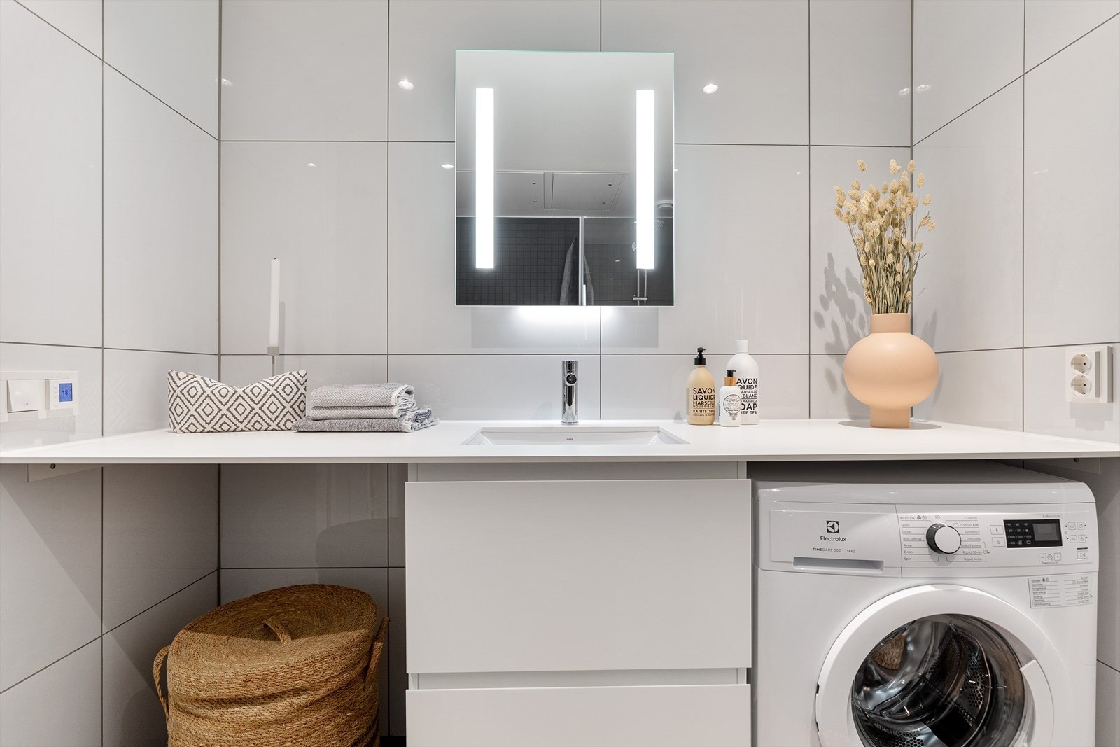 Badet inneholder vegghengt servantskap, speil med belysning og stikkontakt, dusjhjørne samt vegghengt toalett Galleribilde