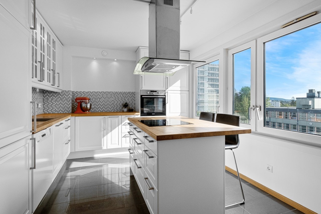 Separat, sosialt kjøkken med stor kjøkkenøy med kokesone og spiseplass - ypperlig for raske frokoster eller lekselesing. Galleribilde